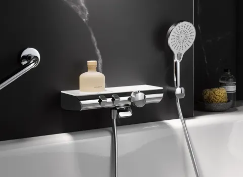 Verchromtes AquaXPro Badewannenthermostat mit Handbrause an einer schwarzen Marmorwand.