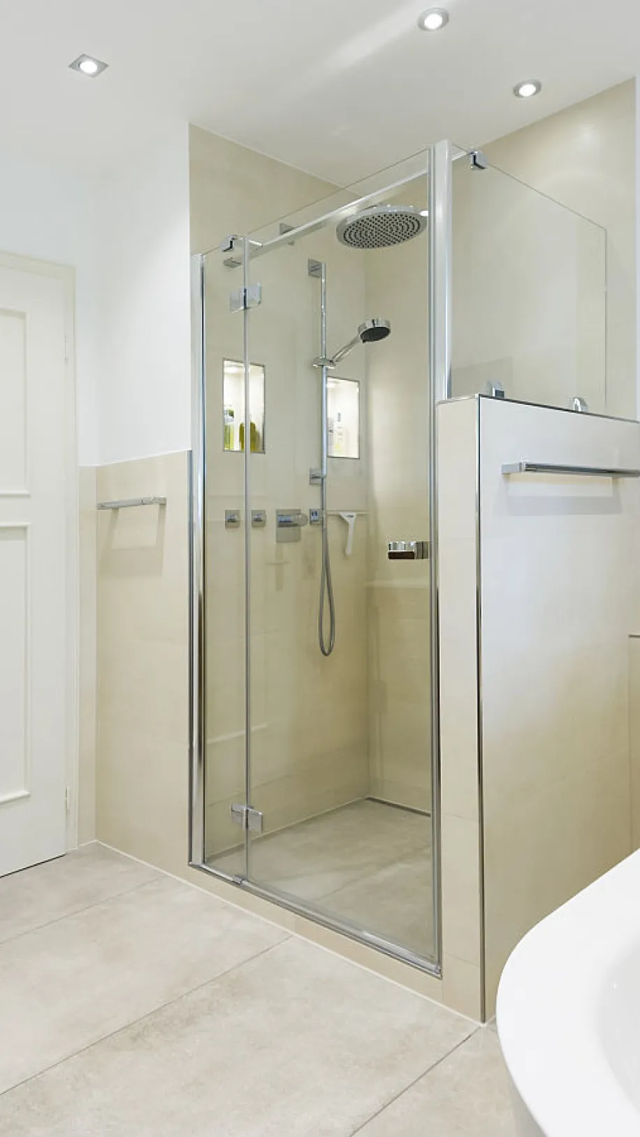 Helles Bad mit einer großzügigen Glasdusche, Badewanne und minimalistischem Design.