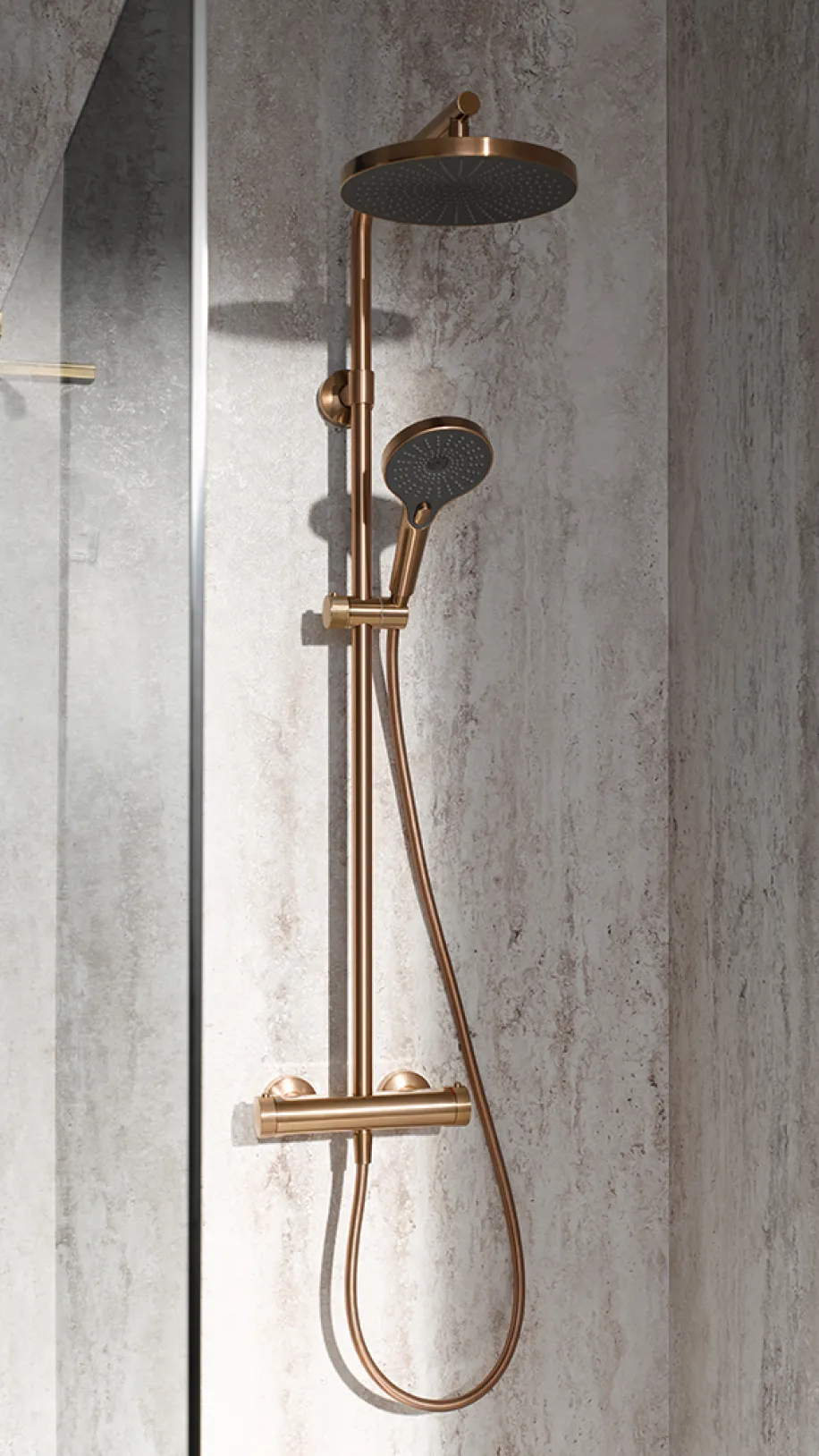 Duschsystem AquaXPro in gebürstetem Kupfer mit Regendusche und Handbrause in einer modernen Walk-in-Dusche.