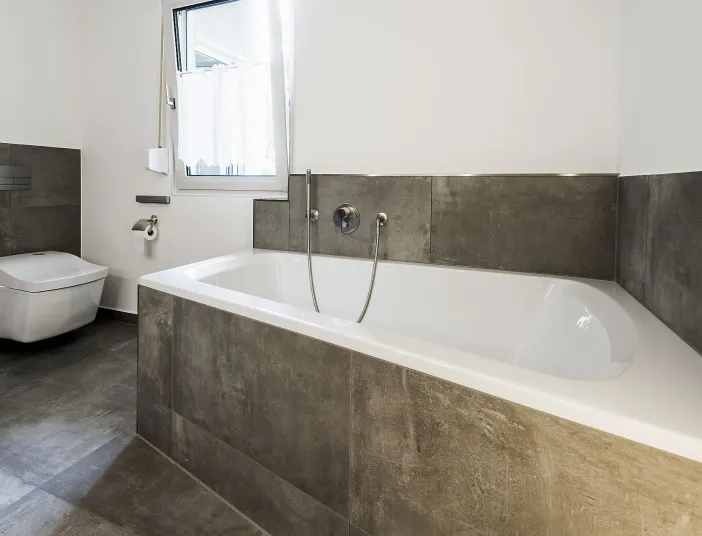 Eckbadewanne von Mauersberger mit Fliesenverkleidung und Unterputzarmatur von Dornbracht.